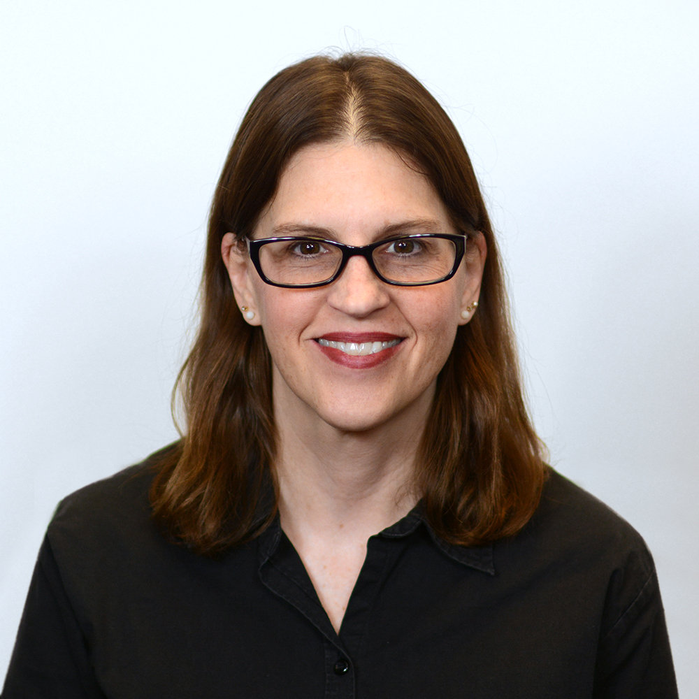 Picture of woman wearing glasses with brown hair and a black blouse